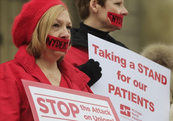 Debbie Nault of the Michigan Nurses Association stands with fellow members of the association on the Capitol steps in Lansing, Mich.  (Photo by Carlos Osorio / AP)