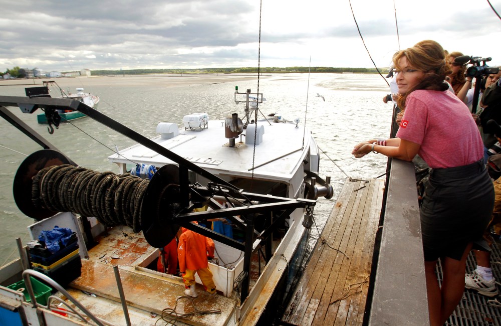 Former Alaska Governor Palin watches a fishing boat unload its catch during a visit to Yankee Seafood Cooperative in Seabrook