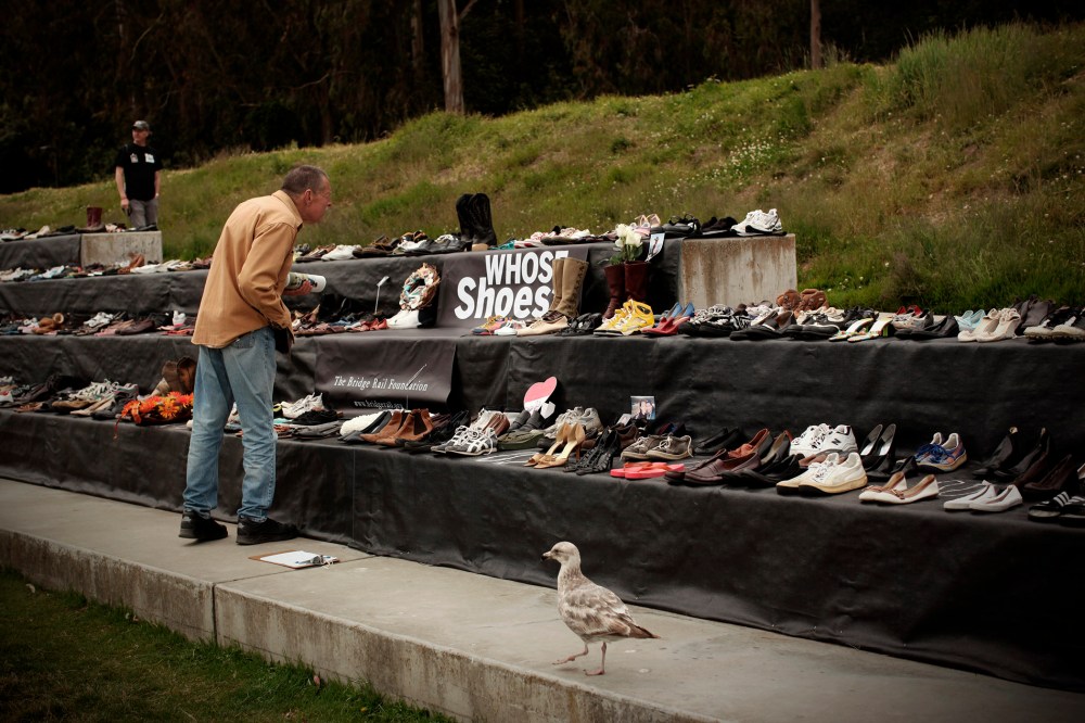 A man looks at a display of more than 1,000 pairs of shoes belonging to people who have jumped to their death from the Golden Gate Bridge in San Francisco, Calif., May 27, 2012. (Photo by Robert Galbraith/Reuters)