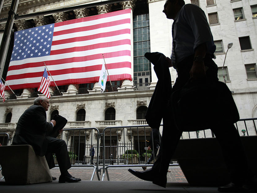 Morning commuters are seen outside the New York Stock Exchange