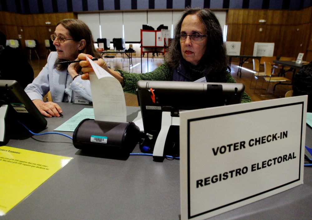 Election judges Jillian Alderbron (R) and Ruth Noel (L) prepare their voter check-in stations at an early voting polling station in Silver Spring, Md., Oct. 27, 2012. (Photo by Gary Cameron/Reuters)