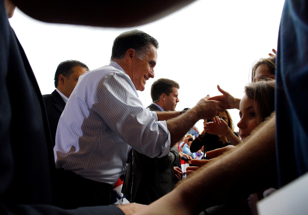 Republican presidential nominee Romney greets audience members at a campaign rally at the airport in Sanford