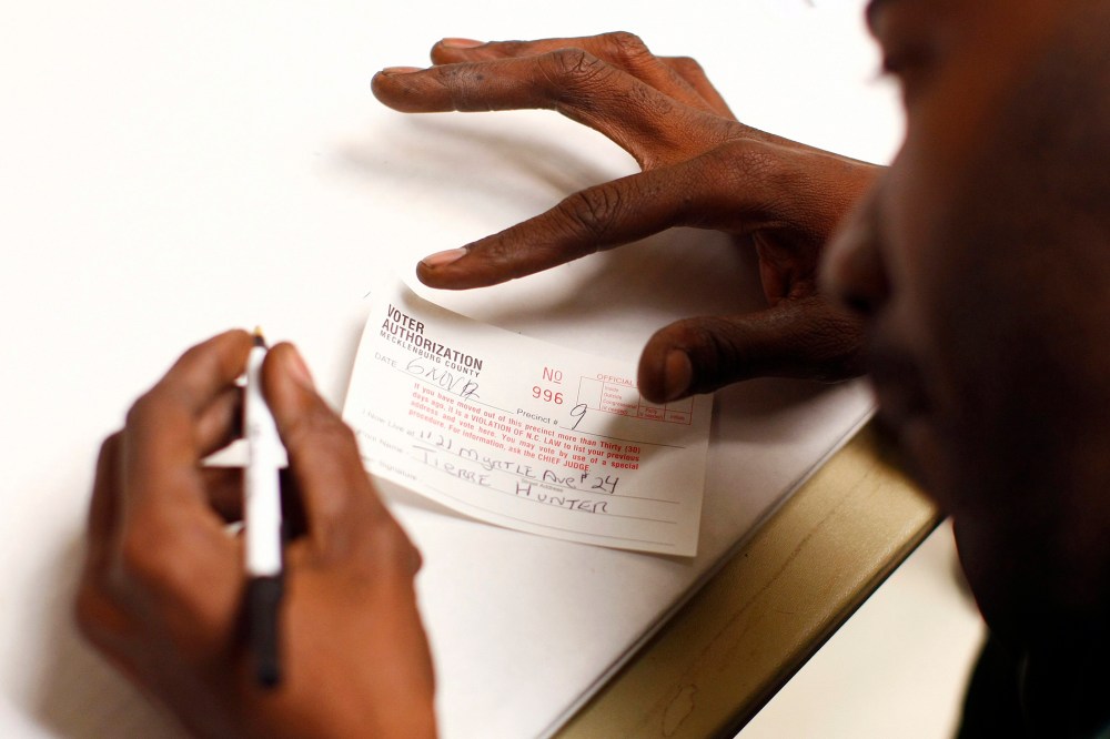 A man fills out a voter authorization form as he arrives to vote in Charlotte, North Carolina, Nov. 6, 2012.