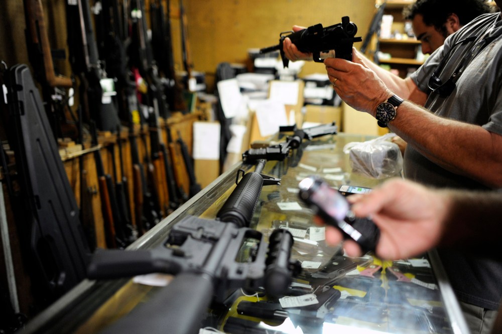 Customers look over the last two AR-15 style rifles for sale inside the Bullet Hole gun shop in Sarasota, Fla., Jan. 16, 2013.