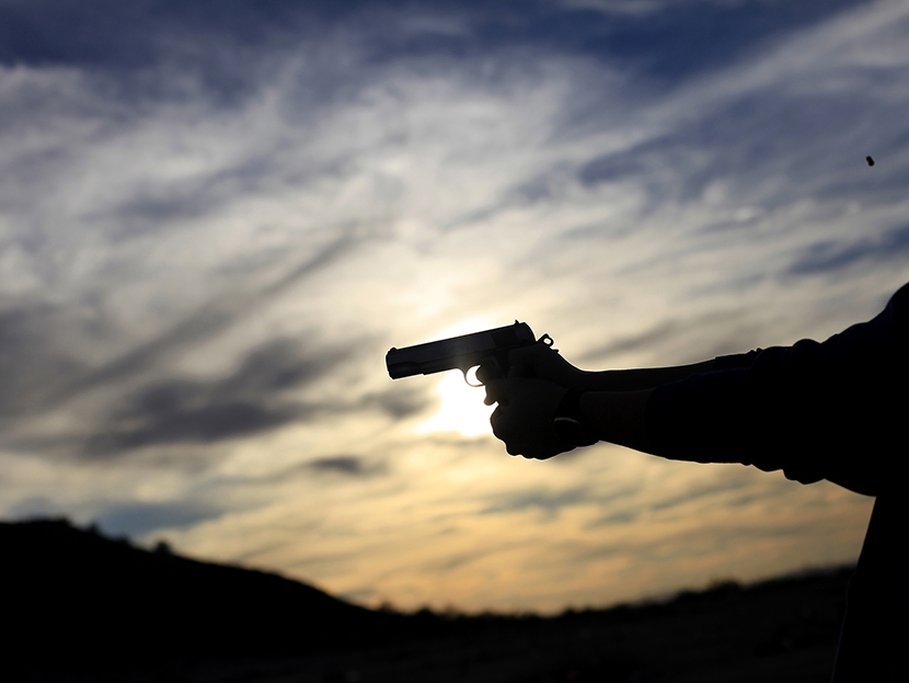 A man fires his handgun along a mountain range in Buckeye, Arizona January 20, 2013. (Photo by Joshua Lott/Reuters)