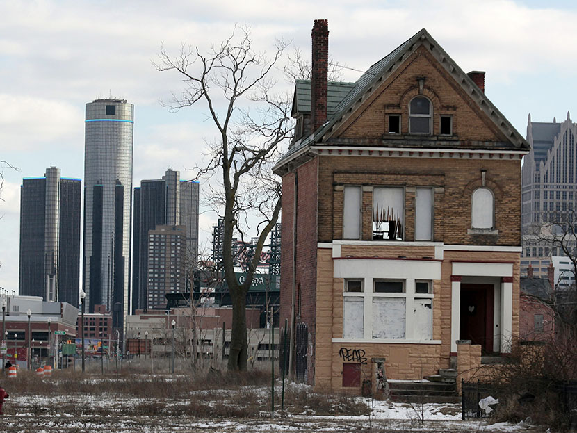 A vacant, boarded up house is seen in the once thriving Brush Park neighborhood with the downtown Detroit skyline behind it in Detroit, Michigan March 3, 2013. (Photo by Rebecca Cook/Reuters)