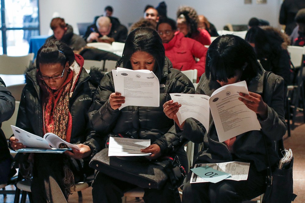 People fill out application forms before a screening session for seasonal jobs at Coney Island in the Brooklyn borough of New York on March 4, 2014.