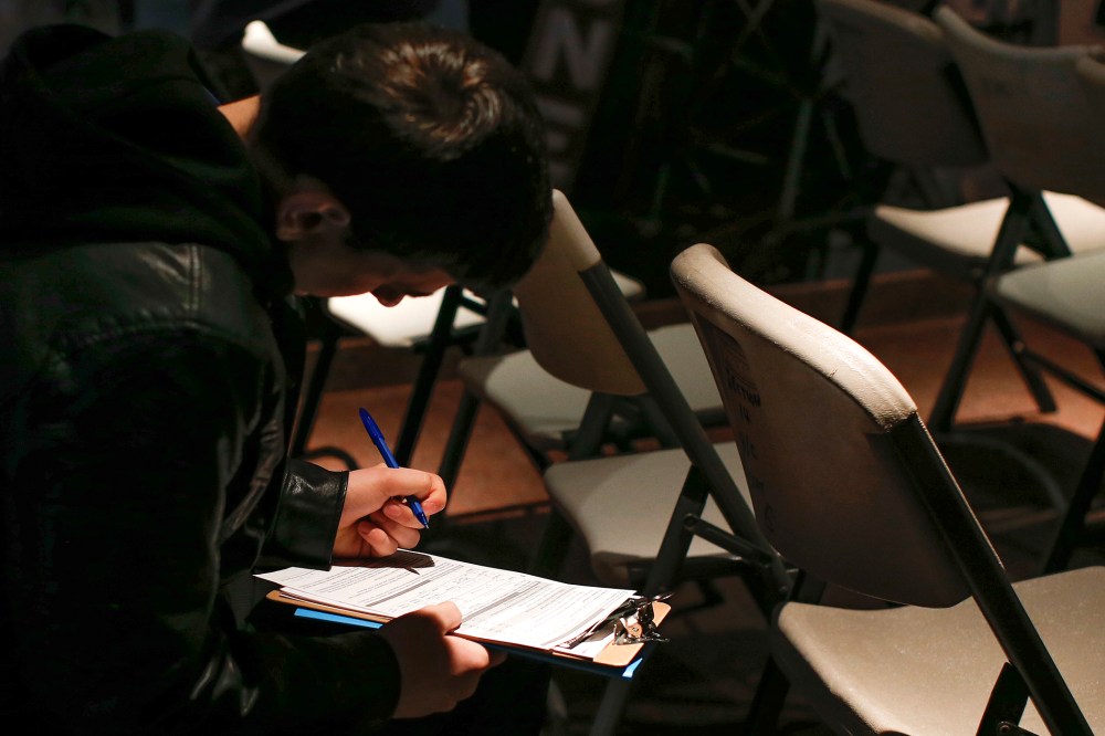 A man fills out paperwork before a screening session for seasonal jobs at Coney Island, March 4, 2014, in Brooklyn, NY.