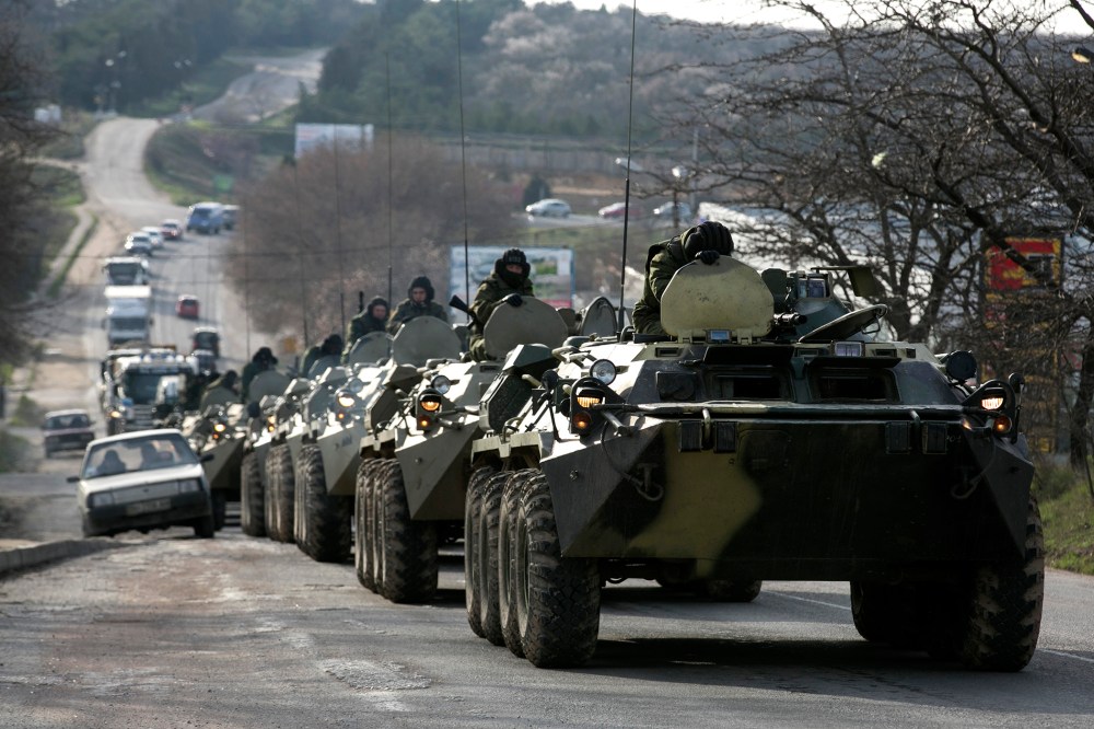 Soldiers, believed to be Russian, ride on military armored personnel carriers on a road near the Crimean port city of Sevastopol on March 10, 2014.