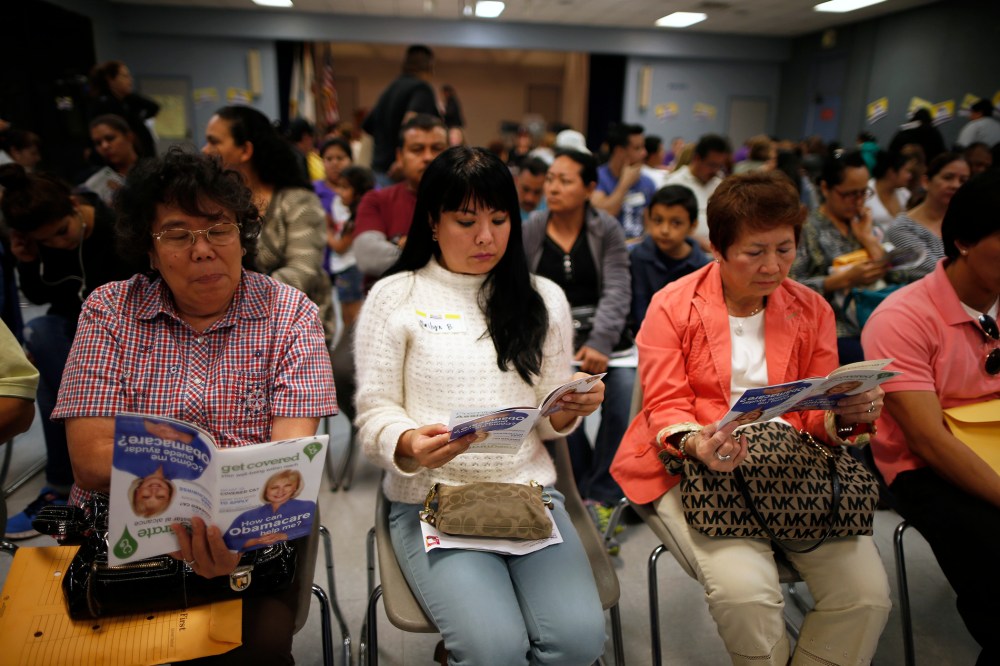 People wait in line at a health insurance enrollment event, March 27, 2014 in Cudahy, Calif.