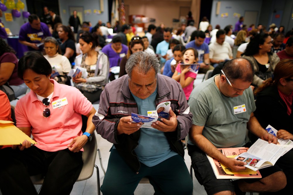 Dominguez, who does not have health insurance, reads a pamphlet at a health insurance enrollment event in Cudahy, California