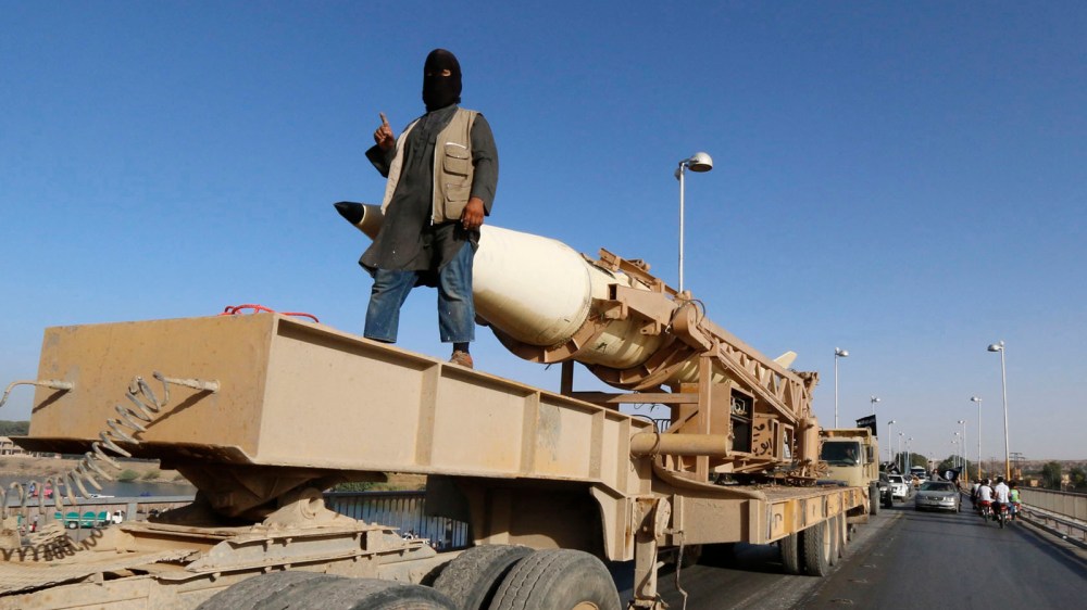 A militant Islamist fighter gestures as he takes part in a military parade along the streets of Syria's northern Raqqa province June 30, 2014.
