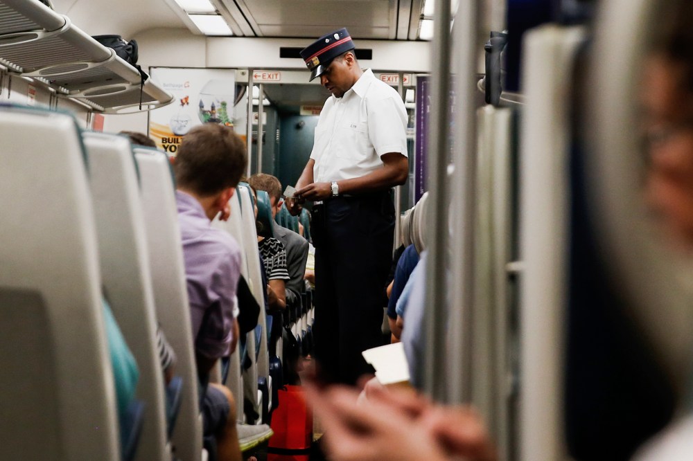 A Long Island Rail Road train conductor collects tickets aboard a train bound for Port Washington leaving Pennsylvania station in New York