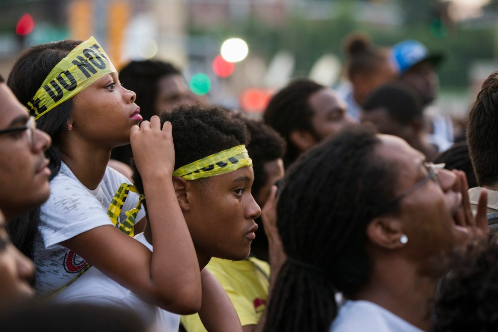 Demonstrators listen to rapper Nelly during a peaceful march in reaction to the shooting of Michael Brown, near Ferguson, Mo., August 18, 2014.