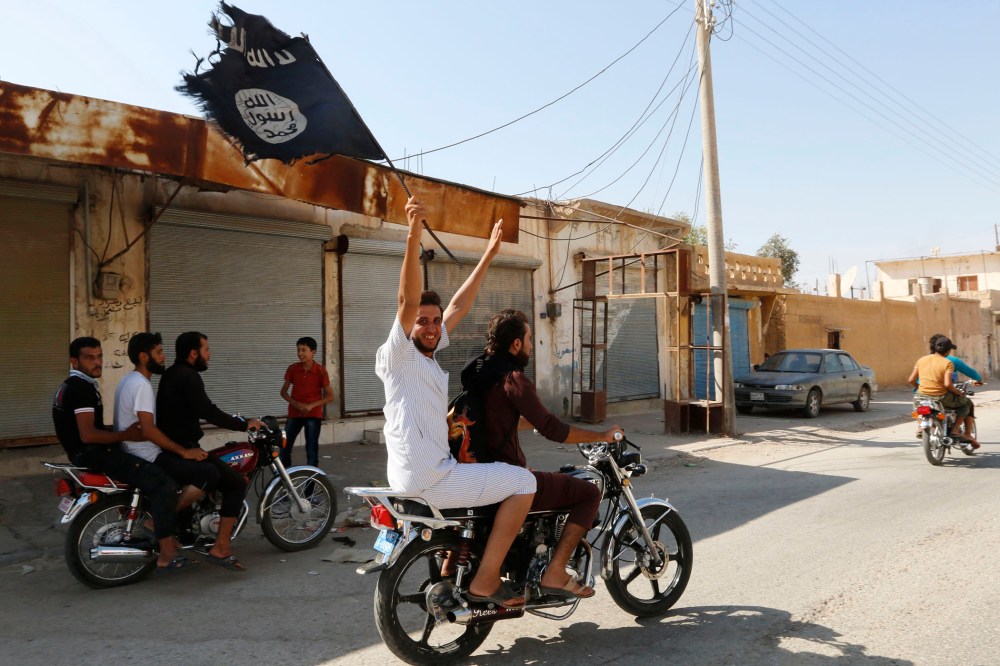 A resident of Tabqa city waves an Islamist flag in celebration after Islamic State militants took over Tabqa air base, in nearby Raqqa city, August 24, 2014.
