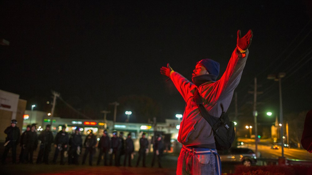 A protester gestures with his hands up in front of police officers during a second night of protests in Ferguson, Mo. on Nov. 25, 2014. (Photo by Lucas Jackson/Reuters)