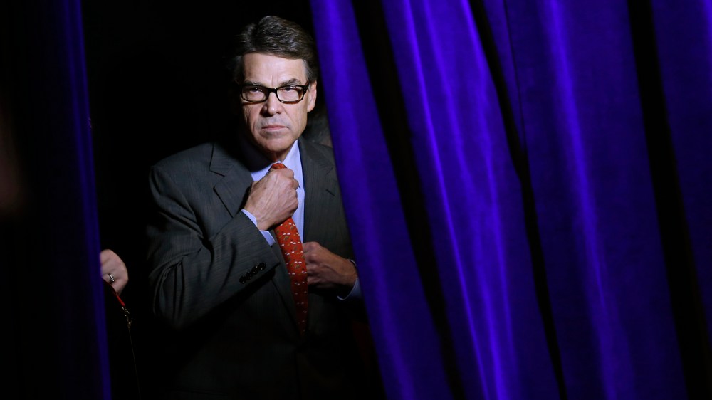 Former Governor of Texas Rick Perry adjusts his tie as he listens to his introduction from the side of the stage at the Freedom Summit in Des Moines, Iowa, Jan. 24, 2015. (Photo by Jim Young/Reuters)