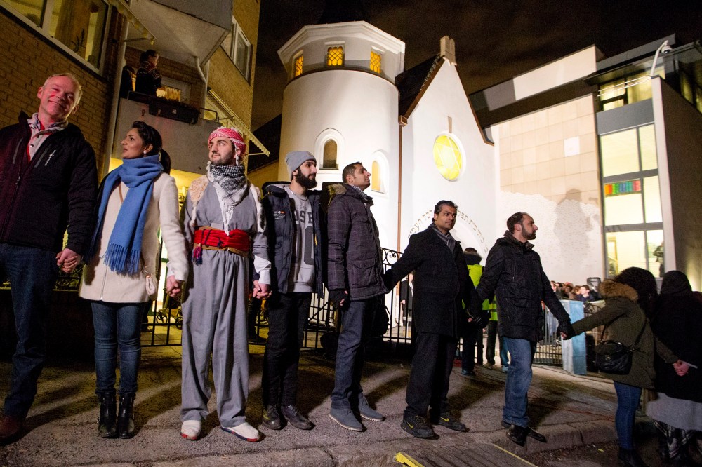 More than 1000 Muslims join hands to form a human shield, dubbed a ring of peace, around a synagogue in Oslo Feb. 21, 2015, offering symbolic protection for the city's Jewish community. (Photo by Hakon Mosvold Larsen/Reuters)