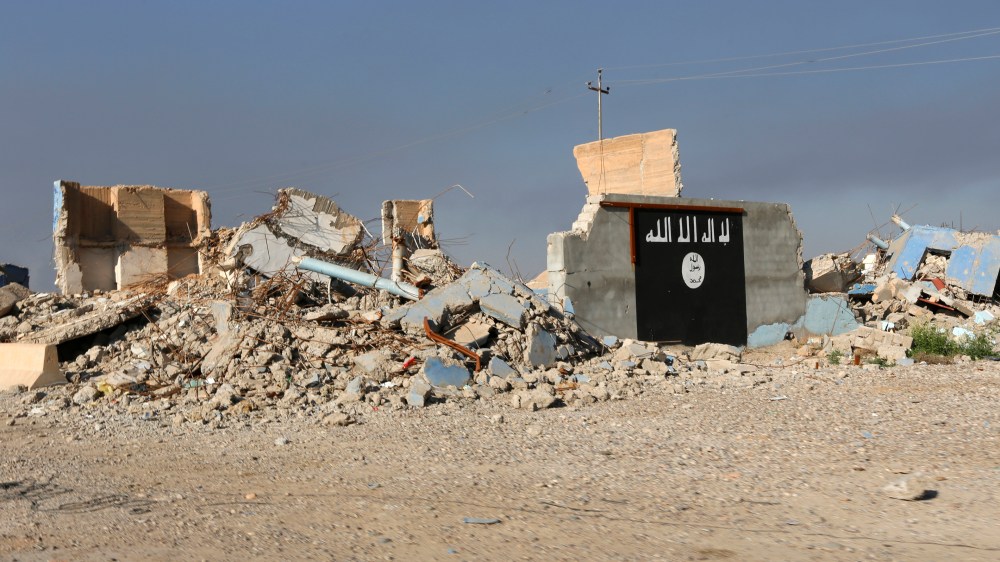 A destroyed building with a wall painted with the black flag commonly used by Islamic State militants, is seen in the town of al-Alam March 10, 2015. (Photo by Thaier Al-Sudani/Reuters)