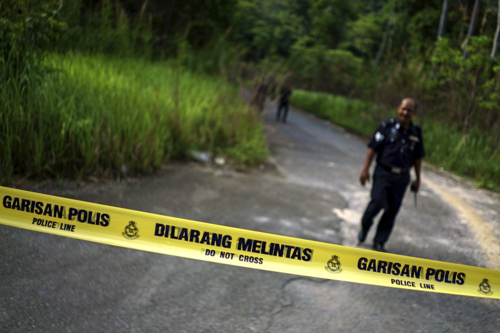 A Malaysian policeman leaves the site of the place where human remains were found, near an abandoned human trafficking camp, in the jungle close to the Thailand border at Bukit Wang Burma in northern Malaysia, May 29, 2015. (Athit Perawongmetha/Reuters)