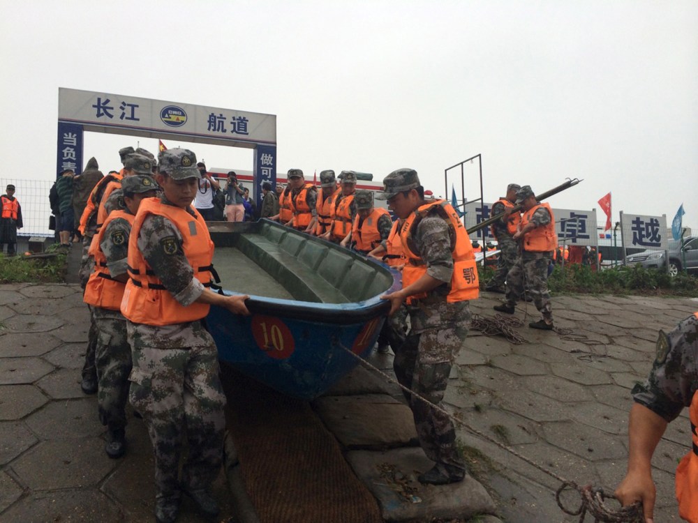 Rescue workers carry a boat as they conduct a search, after a ship sank in the Jianli section of the Yangtze River, Hubei province, China, June 2, 2015. (Photo by Chen Zhuo/Yangzi River Daily/Reuters)