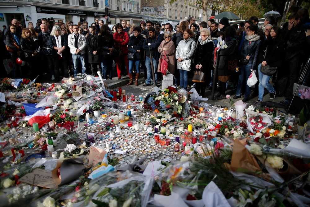 People observe a minute of silence outside the Bataclan music hall to pay tribute to the victims of the series of deadly attacks, in Paris, France, Nov. 16, 2015. (Photo by Christian Hartmann/Reuters)