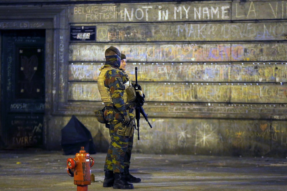 Belgian soldiers patrol, as people pay tribute to the victims of Tuesday's bomb attacks, at the Place de la Bourse in Brussels, Belgium, March 26, 2016. (Photo by Francois Lenoir/Reuters)
