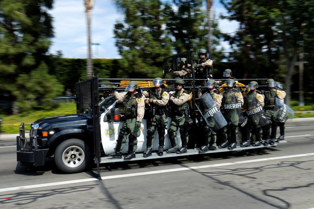 Los Angeles County Sheriffs in riot gear chase demonstrators near Donald Trump's campaign rally in Anaheim, Calif., May 25, 2016. (Photo by Mike Blake/AP)