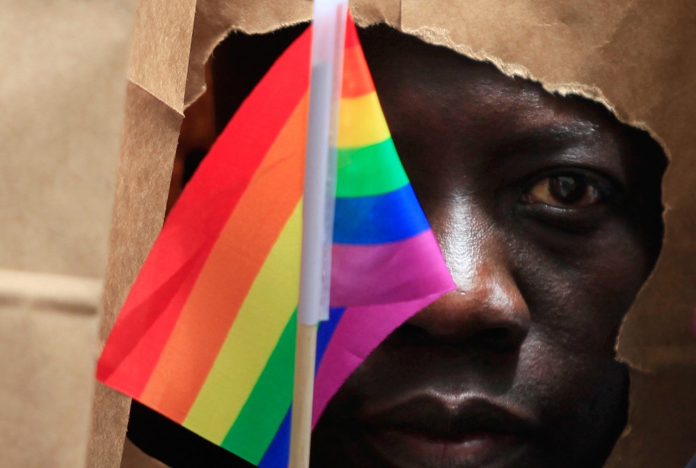 An asylum seeker from Uganda covers his face with a paper bag in order to protect his identity as he marches with the LGBT Asylum Support Task Force during the Gay Pride Parade in Boston, Mass., June 8, 2013. (Photo by Jessica Rinaldi/Reuters)