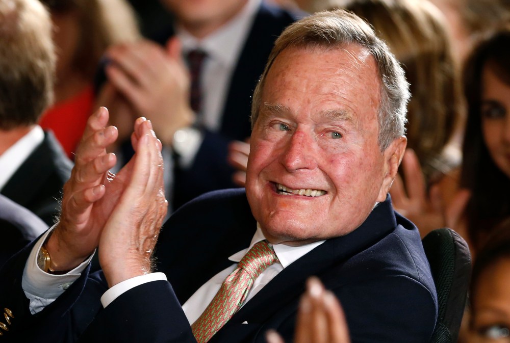 Former President George H. W. Bush applauds during an event at the White House on July 15, 2013.