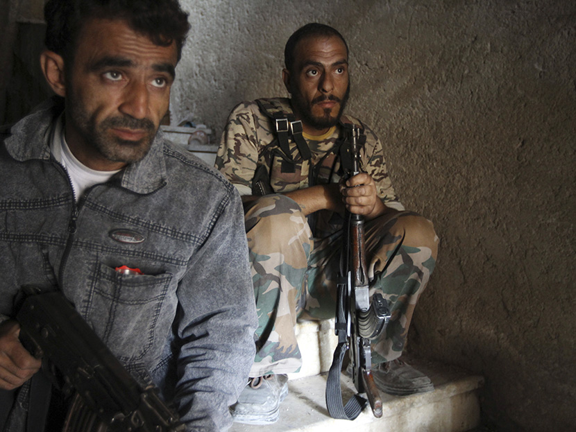 Free Syrian Army fighters take up position on the stairs of a building in Aleppo's Salaheddine neighborhood on July 23, 2013. (Photo by Muzaffar Salman/Reuters)