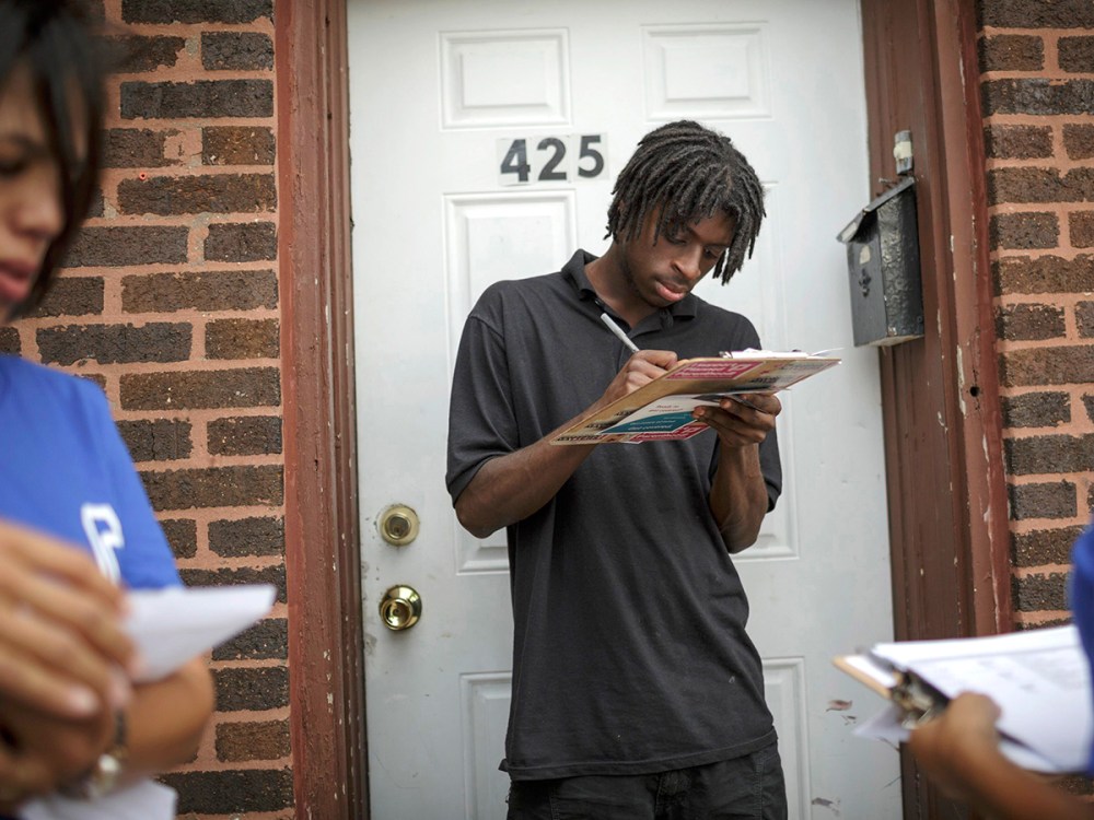 Get Covered America volunteers Cynae Derose (L) and Jalisa Hinkle talk with Daniel Glover about the Affordable Care Act - also known as Obamacare - while canvassing a Chicago, Illinois neighborhood September 7, 2013.
