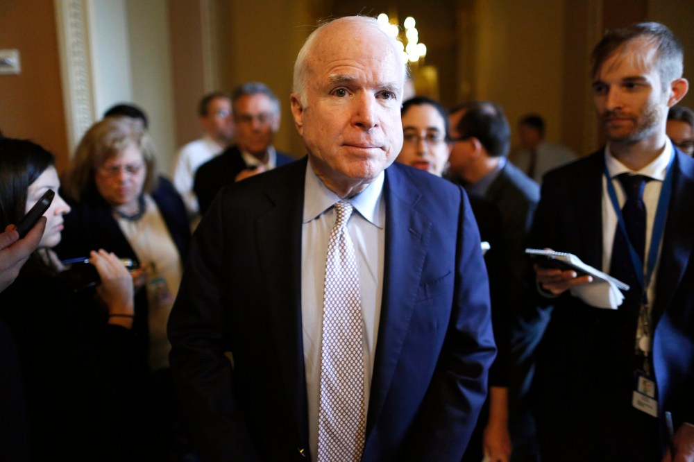 Senator John McCain (R-AZ) (C) talks to reporters on his way to the Senate floor at the U.S. Capitol in Washington, Oct. 12, 2013.