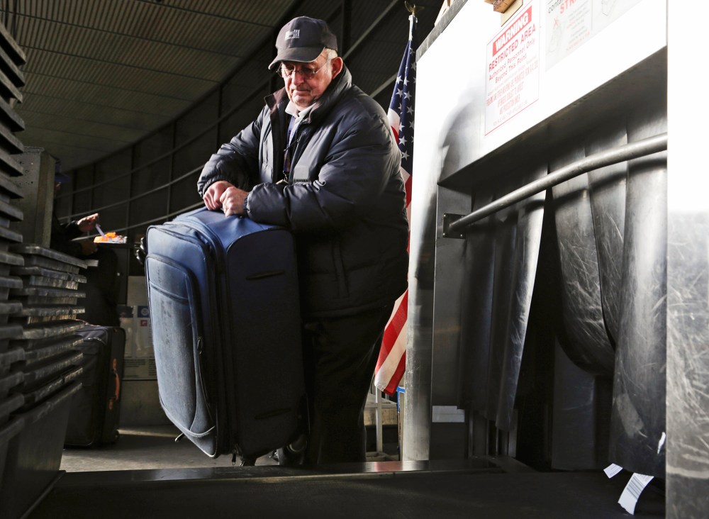 Sky Cap worker Tim Weiler, 67, checks curbside luggage at Seattle-Tacoma International Airport in SeaTac, Washington, October 30, 2013.
