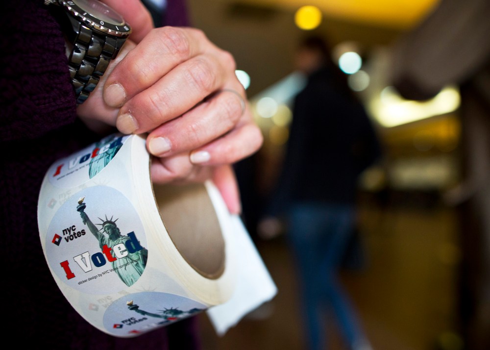A door clerk waits to hand stickers to voters after they cast their votes for the New York Mayoral Election at the Congregation Mount Sinai in New York November 5, 2013.