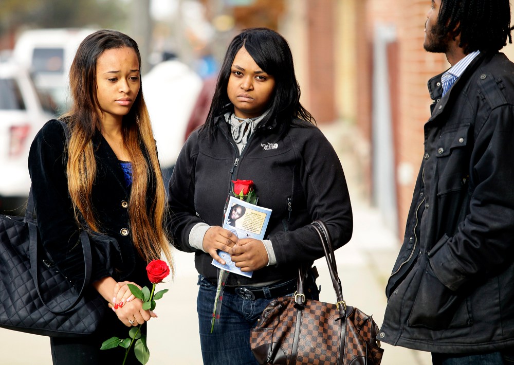 Mourners hold roses after the funeral service for 19-year-old shooting victim Renisha McBride in Detroit, Michigan, November 8, 2013.