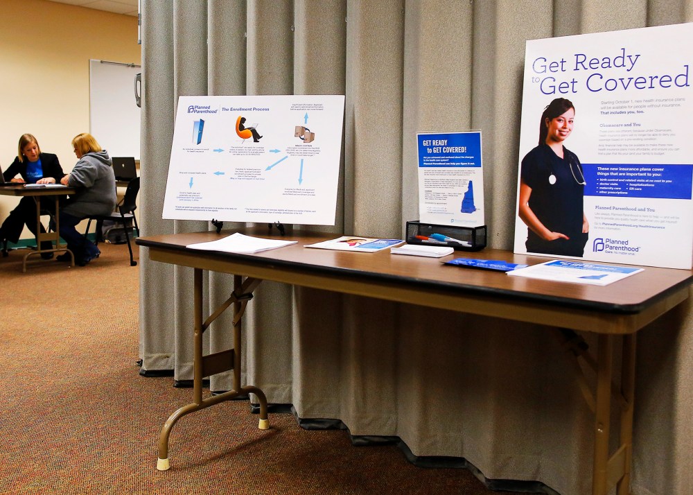 A navigator helps a woman seeking health insurance at an enrollment fair in Portsmouth, NH, Nov. 9, 2013.