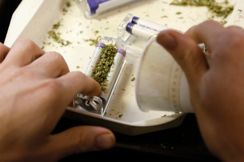 A worker rolls marijuana joints for sale at the Botanacare marijuana store ahead of their grand opening on New Year's day in Northglenn, Colo. Dec. 31, 2013.