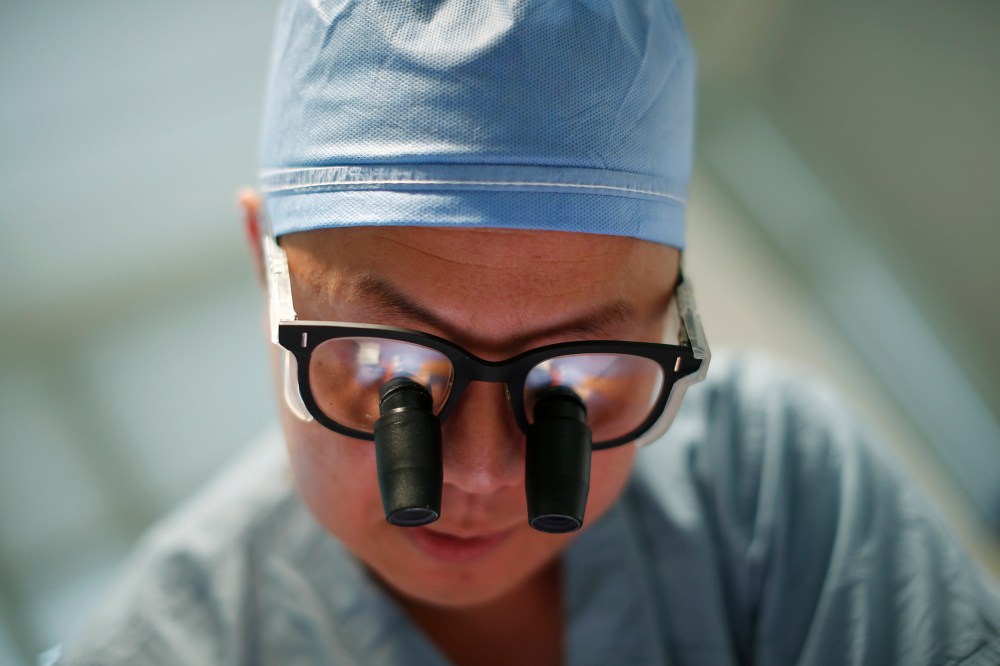 Doctor Andy Chiou operates on a patient in Peoria, Ill., Nov. 26, 2013.