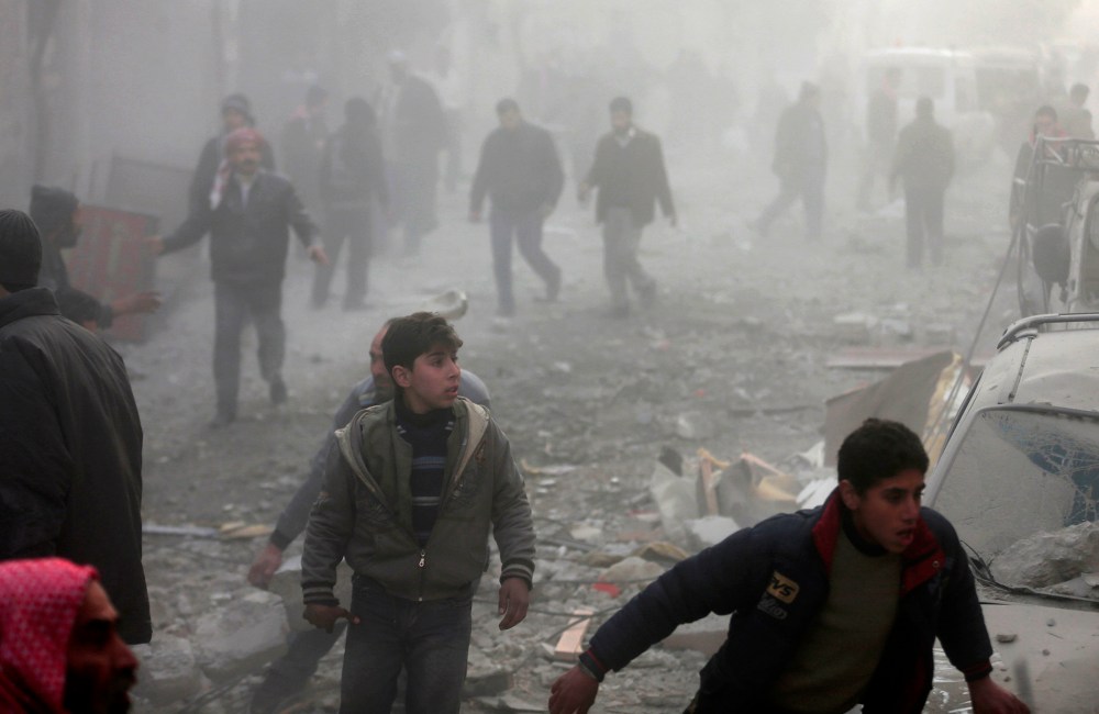 People rush after what activists said was an airstrike by forces loyal to Syrian President Bashar al-Assad in the Duma neighbourhood of Damascus