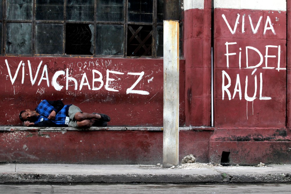 A man sleeps near graffiti in Havana on Jan. 16, 2014.