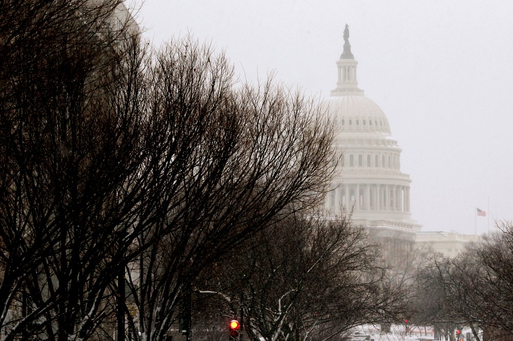 A pedestrian walks across New Jersey Avenue in front of the U.S. Capitol building.