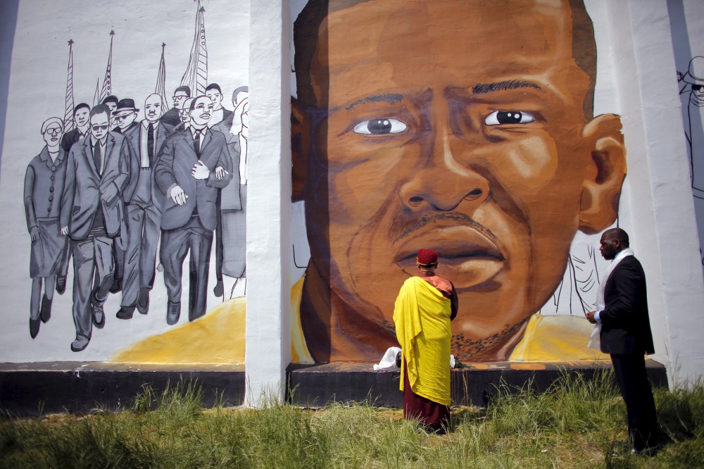 Gyalwang Drukpa, a Buddhist leader from South Asia, prays in front of a mural of Freddie Gray in Baltimore, Md., May 7, 2015. (Photo by Carlos Barria/Reuters)