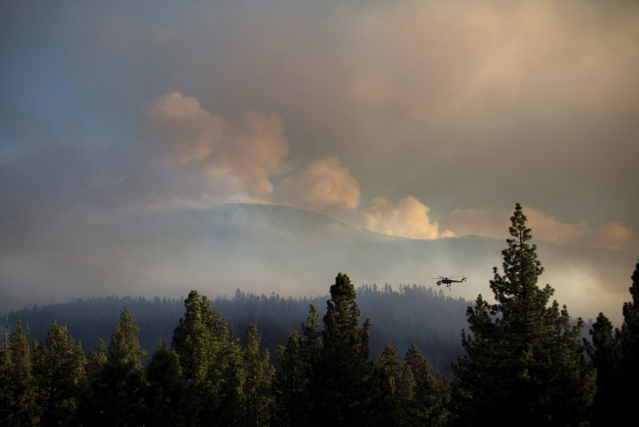 A firefighter helicopter flies near the Lake Fire in the San Bernardino National Forest, Calif., June 19, 2015. (Photo by David McNew/Reuters)