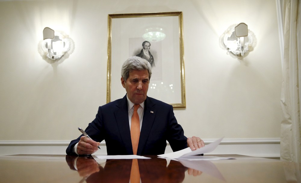 Secretary of State John Kerry signs the certification to the U.S. government that IAEA certified Iran's compliance in their report, requesting the lifting of the nuclear-related sanctions, Vienna, Jan. 16, 2016. (Photo by Kevin Lamarque/Reuters)
