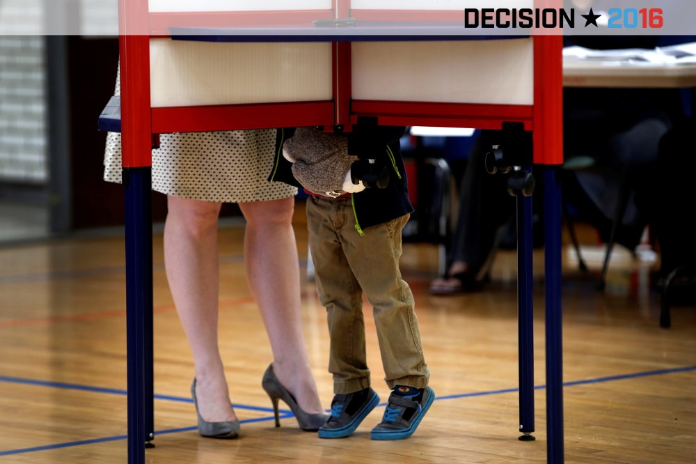 A woman fills out her ballot in a voting booth in the New York, in the U.S. presidential primary election, as her young son looks on, Grafflin School in Chappaqua, N.Y., April 19, 2016. (Photo by Mike Segar/Reuters)
