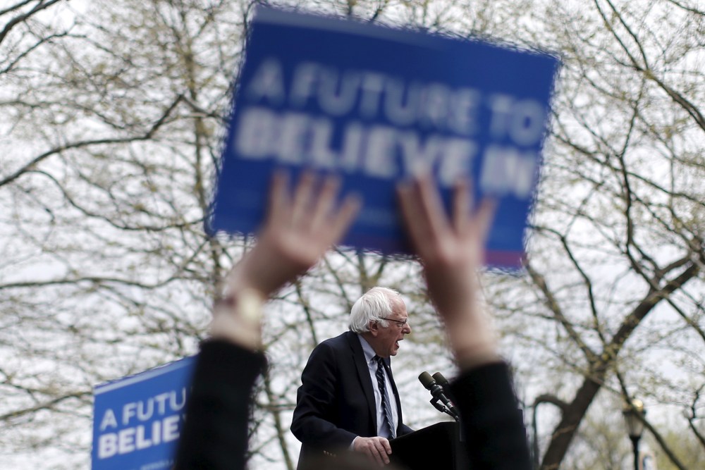 U.S. Democratic presidential candidate Bernie Sanders is seen between the arms a supporter waving a sign as he speaks at a campaign rally in Hartford, Conn. on April 25, 2016. (Photo by Mike Segar/Reuters)