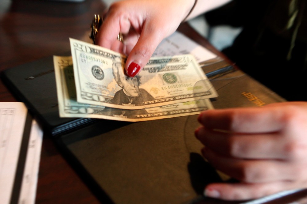 A customer pays her lunch bill at the Other Side Cafe in Boston