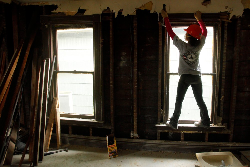 Americorps worker Yoshi Batcho helps gut a house being renovated into affordable housing by PUSH, a non-profit organization working to rebuild the West Side of Buffalo, New York, Nov. 19, 2009.