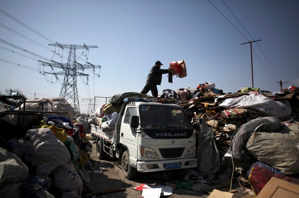 A worker unloads waste at the Xiejiacun waste collection market in the Changping district of Beijing  on April 8, 2013.